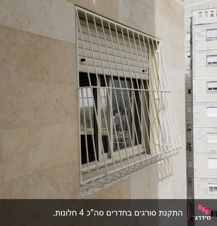 חלון עם סורגים לבנים על קיר חיצוני